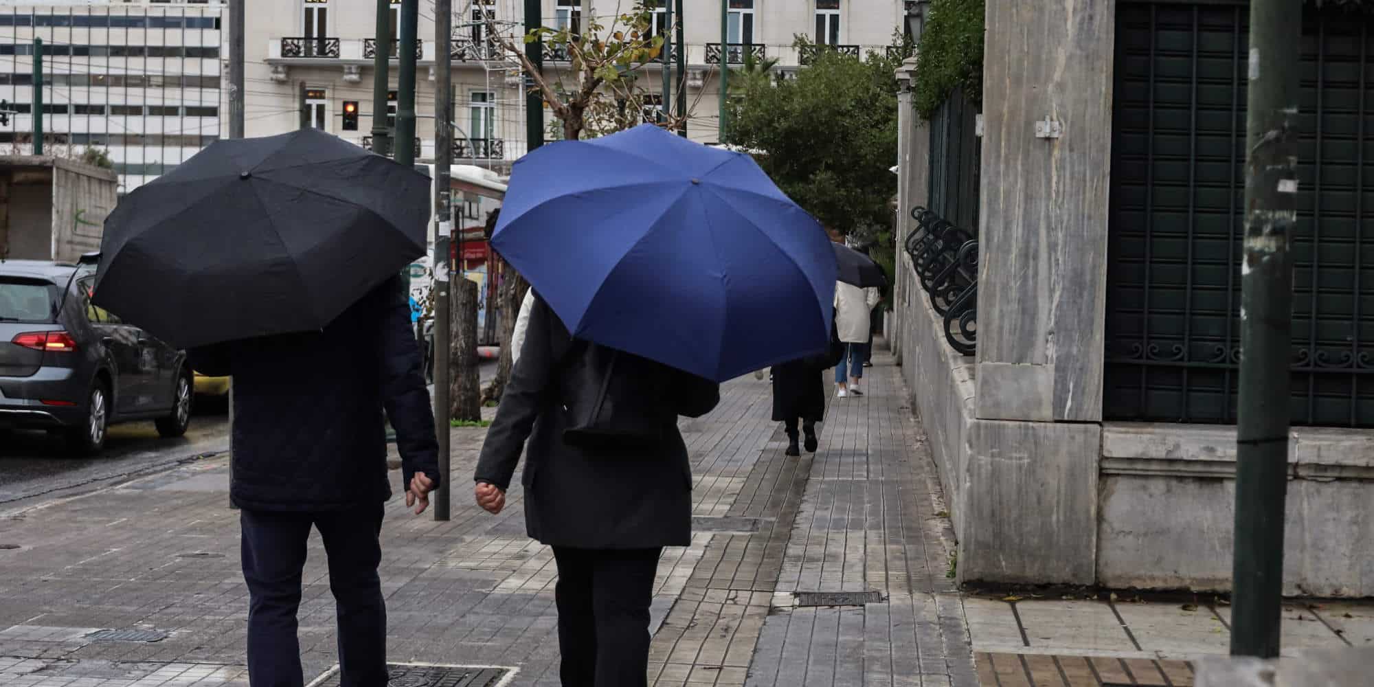 Άστατος καιρός και βροχή στο κέντρο της Αθήνας, πολίτες με ομπρέλες στο πεζοδρόμιο / Φωτογραφία: Eurokinissi