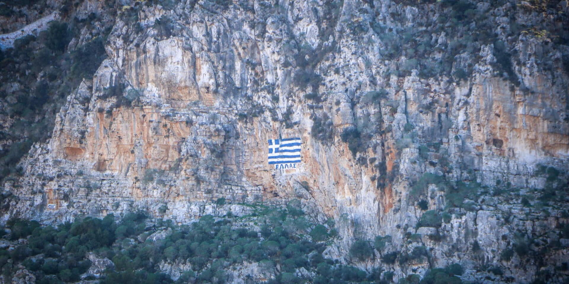 Η λέξη Ελλάδα, πλάι στη γαλανόλευκη στα βράχια της Ρω