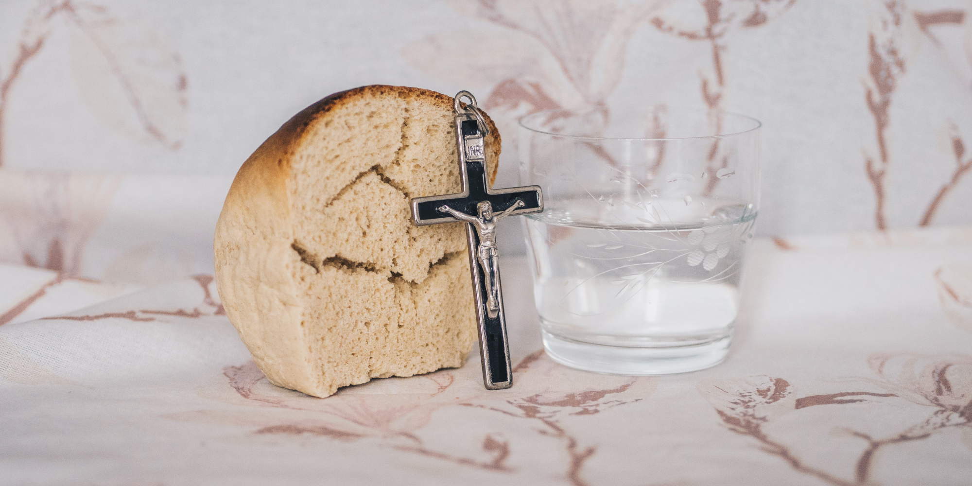 Η Σαρακοστή είναι περίοδος για νηστεία. Ψωμί και σταυρός πλάι σε ποτήρι νερό