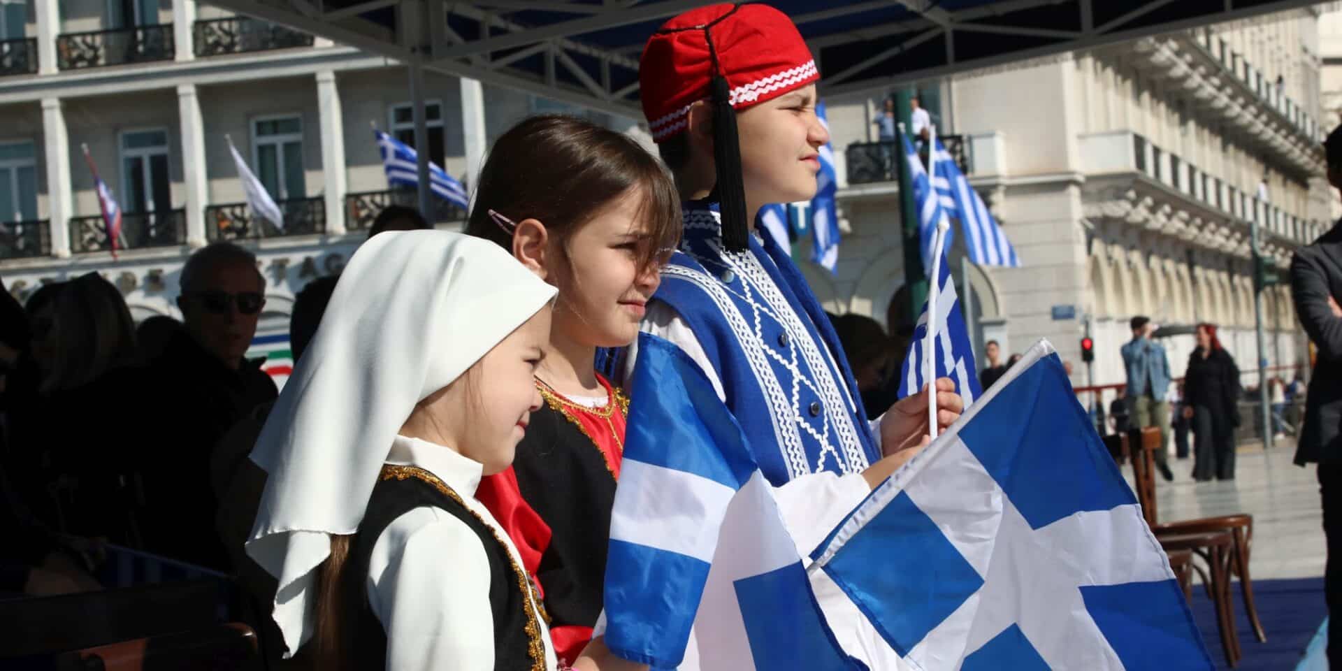 Μαθητές ντυμένοι τσολιάδες παρακολουθούν την παρέλαση για την 25η Μαρτίου