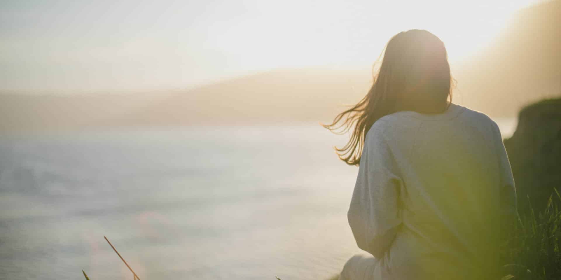 Γυναίκα πλάτη ατενίζει το ηλιοβασίλεμα / Φωτογραφία: Unsplash