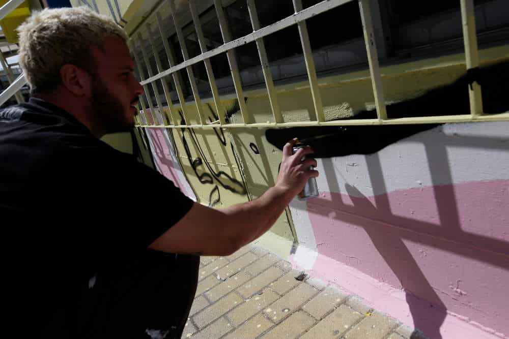 Ο καλλιτέχνης που ολοκληρώνει το γκράφιτι στο σχολείο / Φωτογραφία: ΑΠΕ