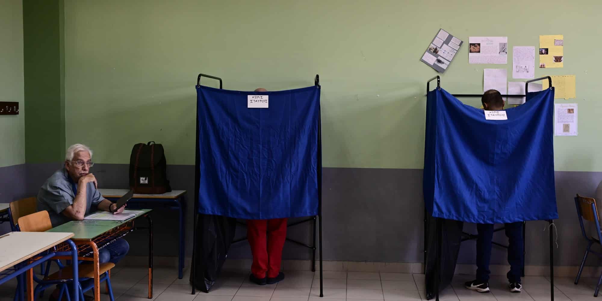 Κόσμος ψηφίζει μέσα στο παραβάν για τις εκλογές - κάλπες