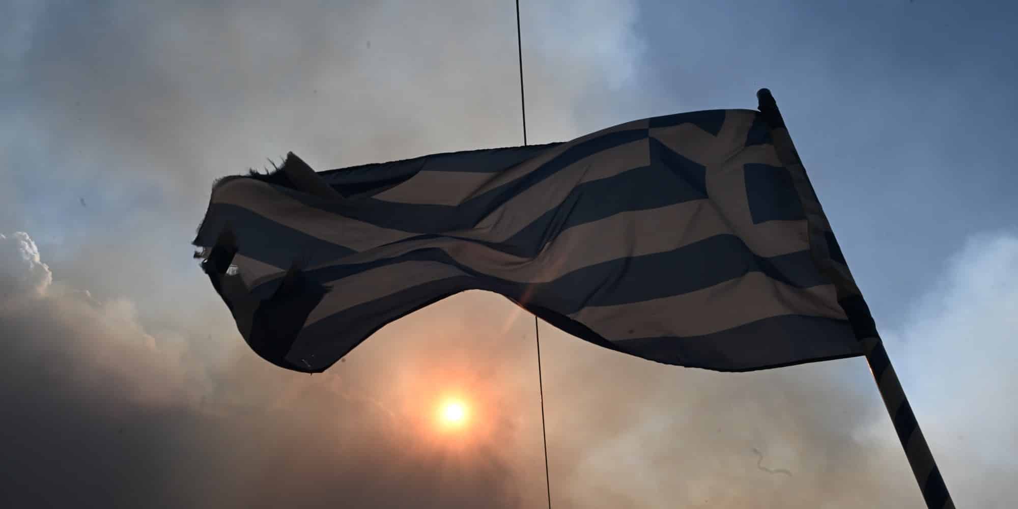 Ελληνική σημαία και από πίσω καπνός φωτιάς