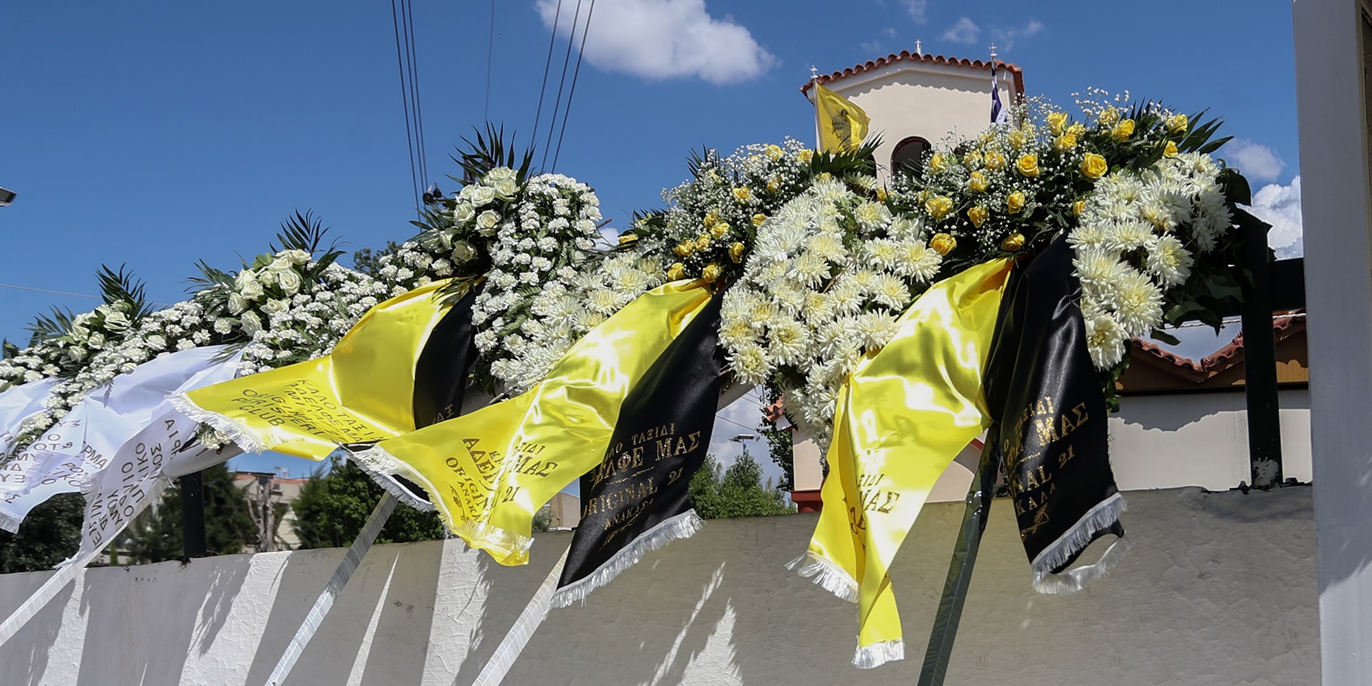 Τα στεφάνια στην κηδεία του Μιχάλη Κατσουρή ο οποίος δολοφονήθηκε στη Νέα Φιλαδέλφεια